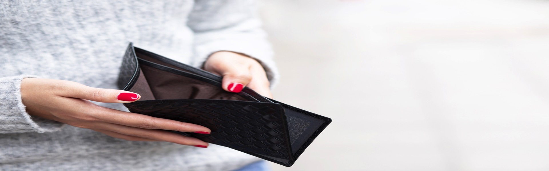 Prázdna peňaženka v rukách ženy ako znak pre finančné problémy